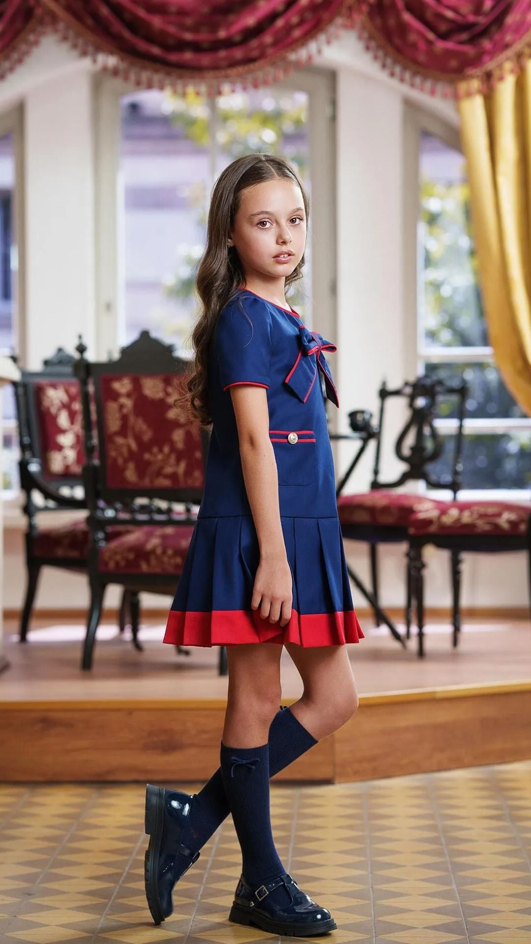 Girls’ Navy Blue Pleated Dress with Red Trim & Bow
